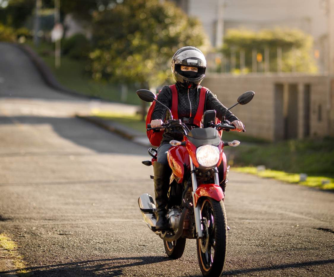 Motociclista pilotando moto vermelha